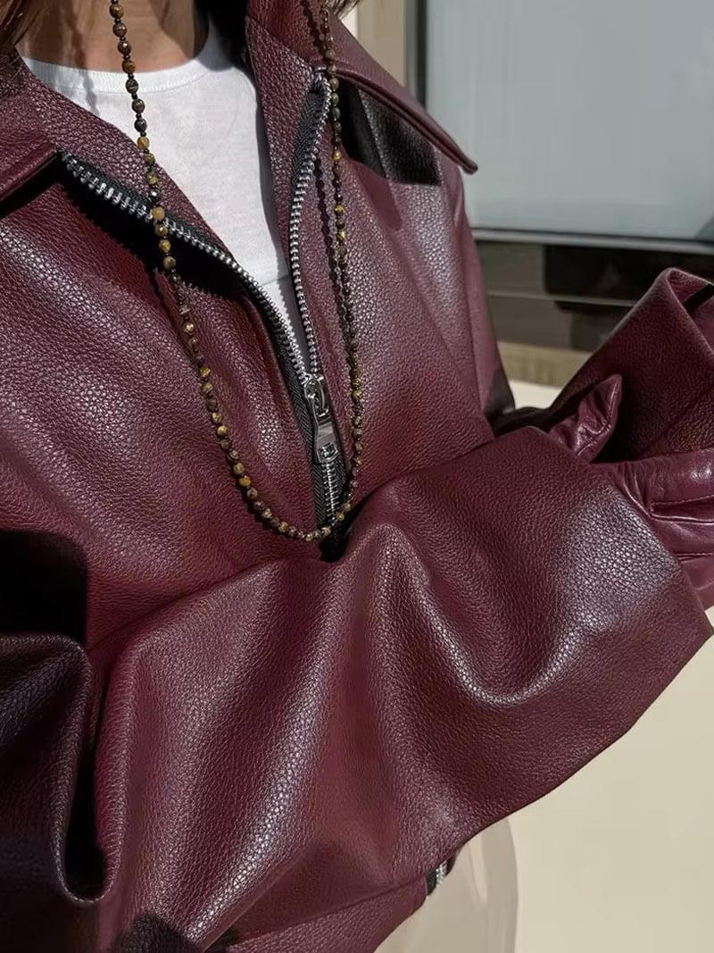 "Bordeauxrode leren damesjas, elegant en edgy, met zilverkleurige details en getailleerde pasvorm voor een stijlvolle look."