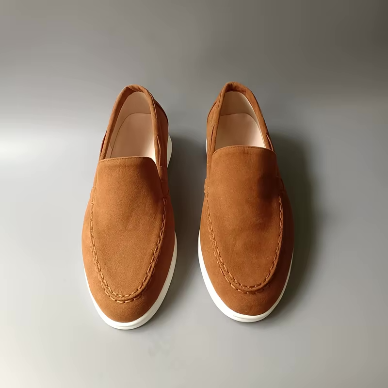 "Casual suède-look herenschoen met moderne witte zool; instapmodel zonder veters voor comfort en stijl."