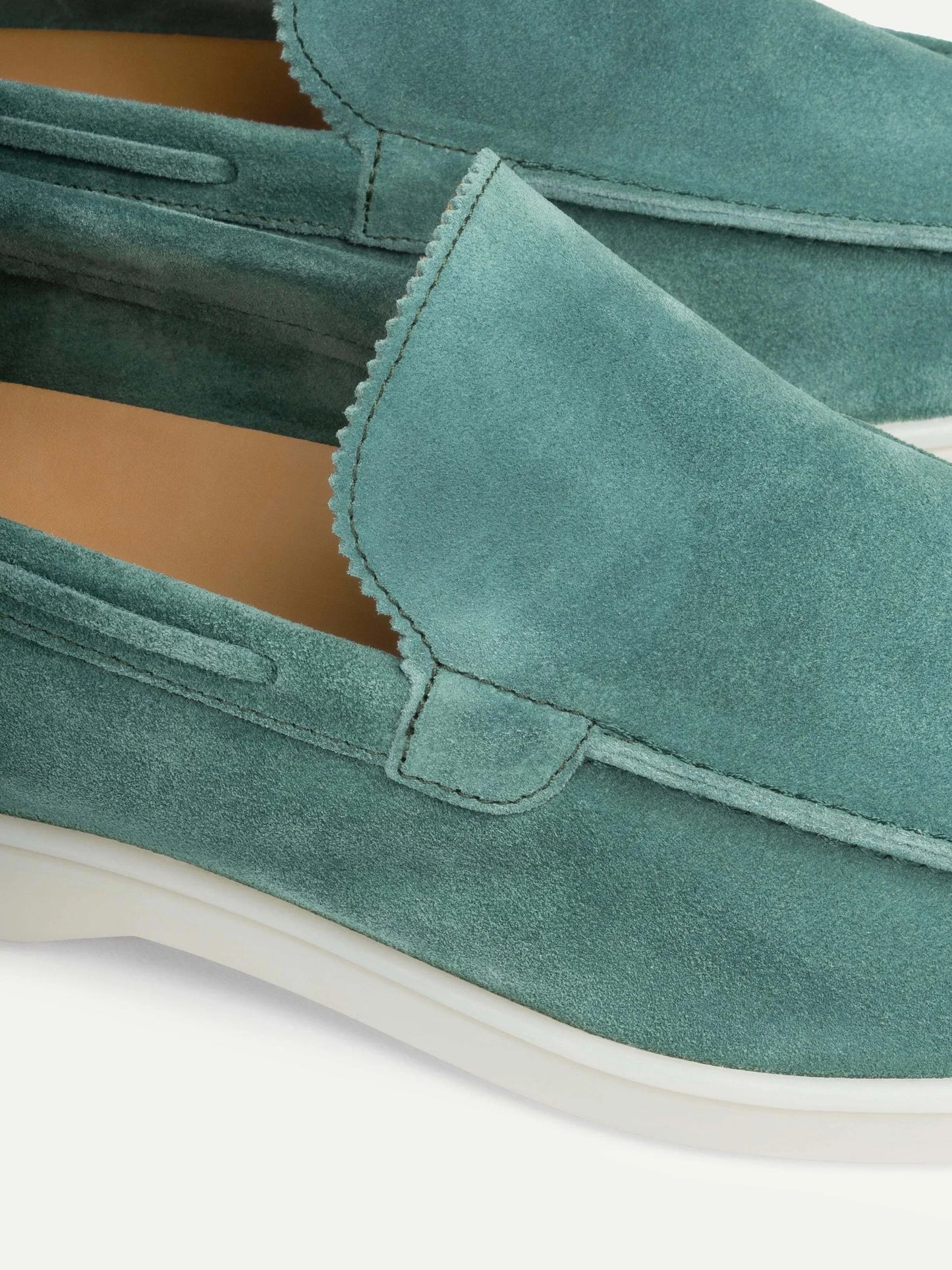 "Casual suède-look herenschoen met moderne witte zool; instapmodel zonder veters voor comfort en stijl."