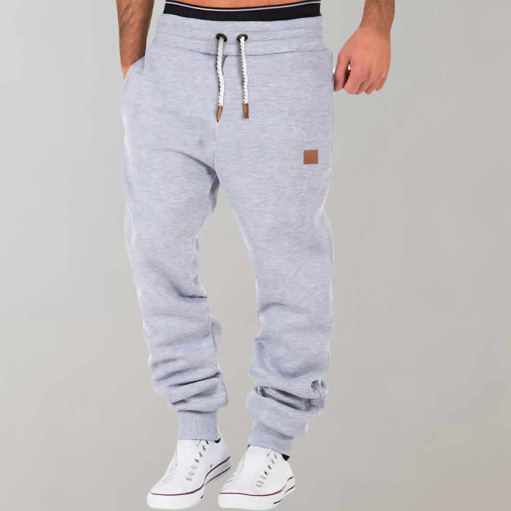 "Comfortabele heren joggingbroek met baggy pasvorm, grijs van kleur, verstelbare tailleband, ideaal voor sport en casual."