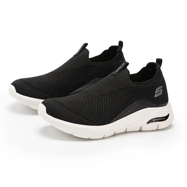 "Comfortabele zwarte slip-on sneakers voor dames, minimalistisch design, ademend materiaal, ideale casual schoenen."