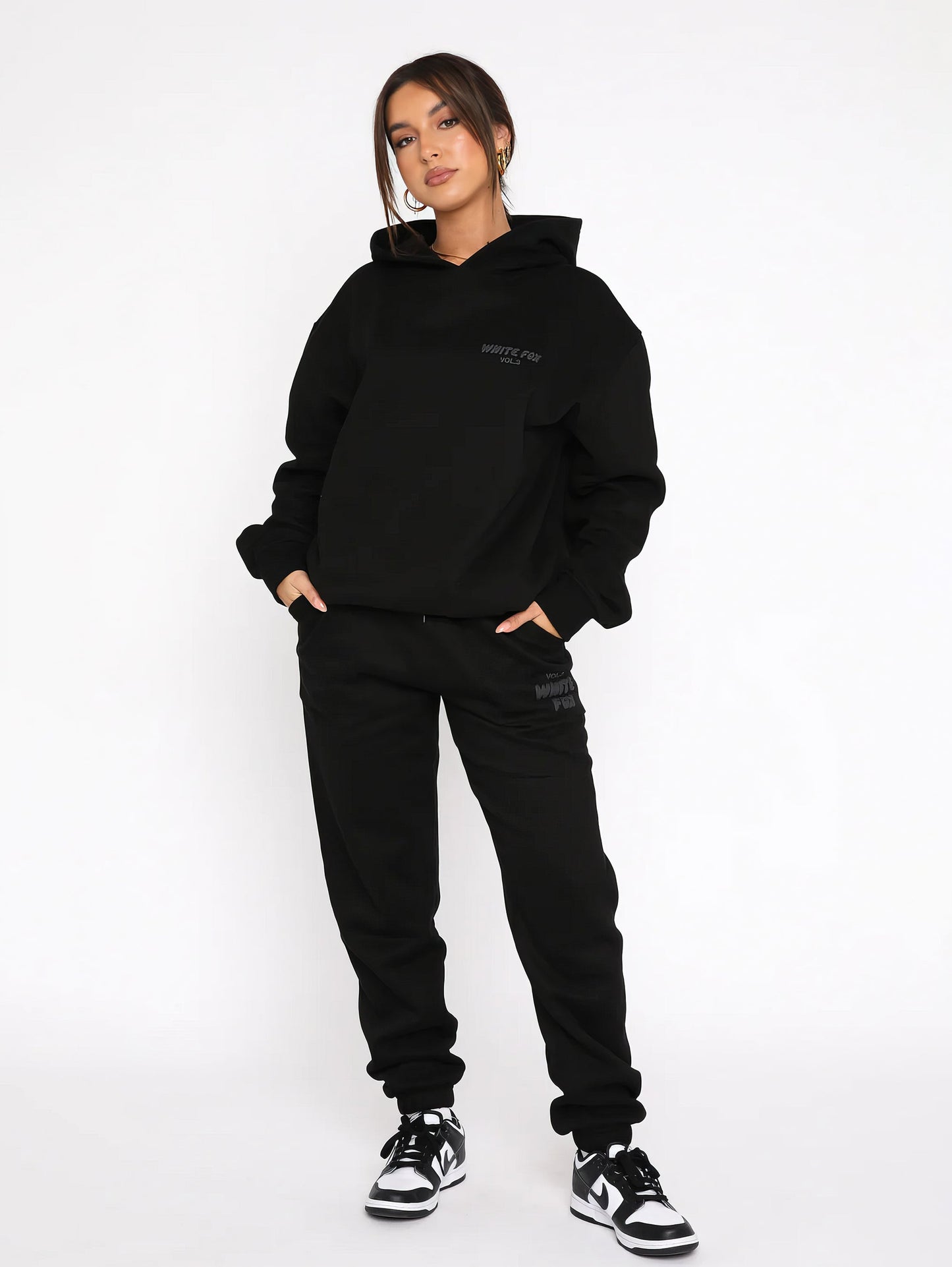 "Dames trainingspak met oversized pasvorm, wit, elastische ribboorden, trendy puffprint logo en fleecestof."