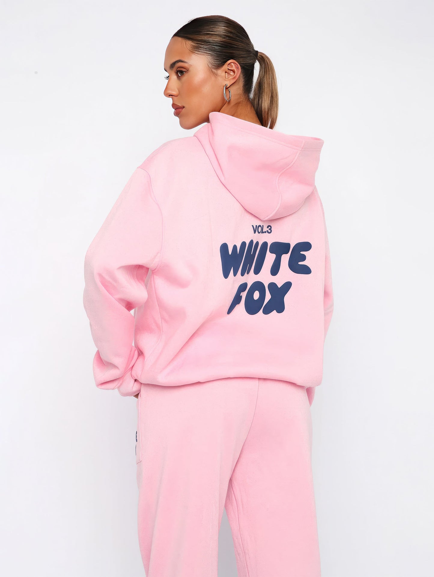 "Dames trainingspak met oversized pasvorm, wit, elastische ribboorden, trendy puffprint logo en fleecestof."