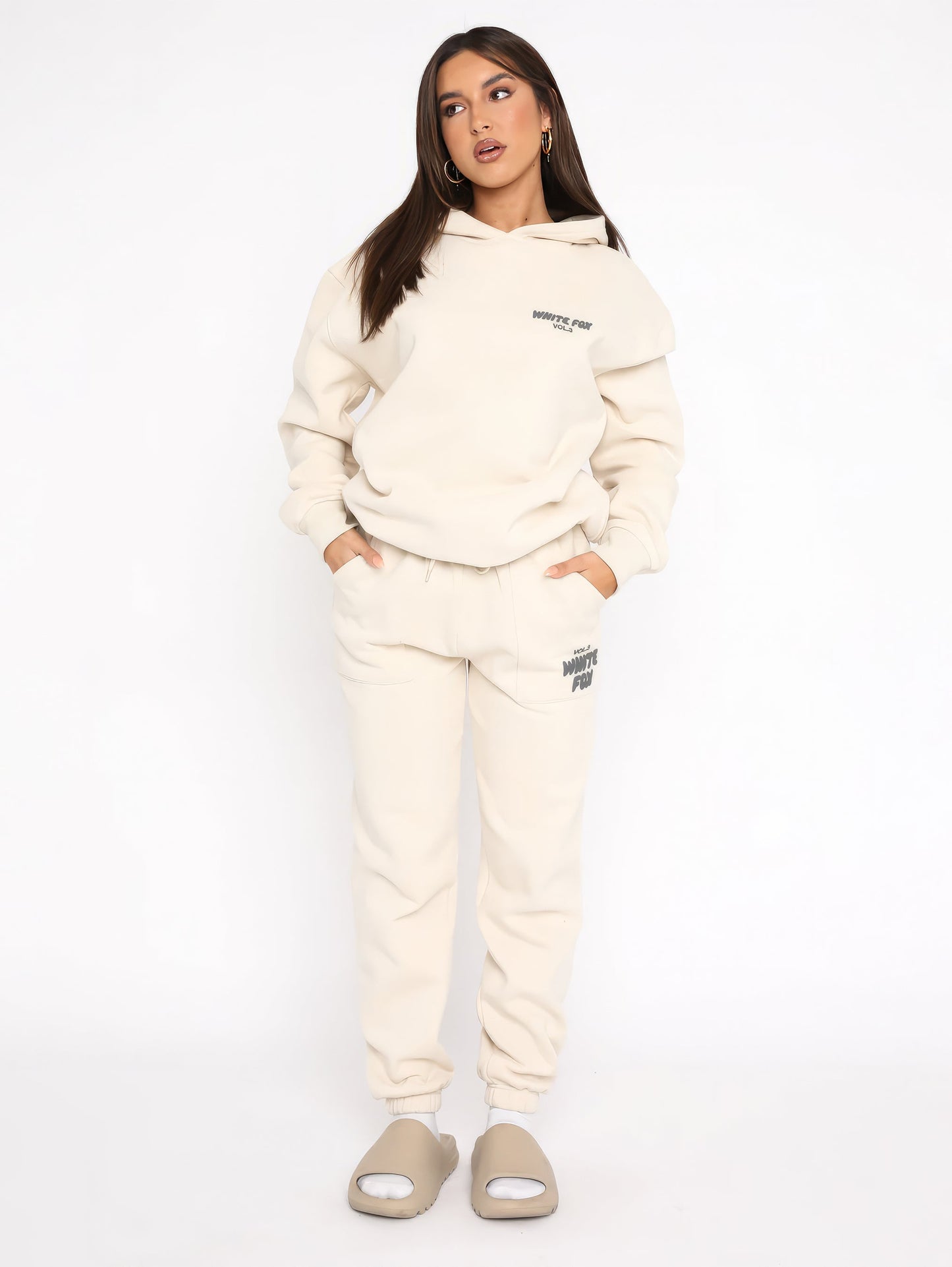 "Dames trainingspak met oversized pasvorm, wit, elastische ribboorden, trendy puffprint logo en fleecestof."