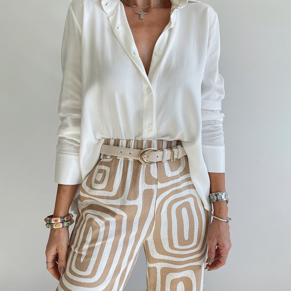 "Damesoutfit met witte blouse en trendy beige printbroek, stijlvolle en modieuze combinatie voor dagelijks gebruik."
