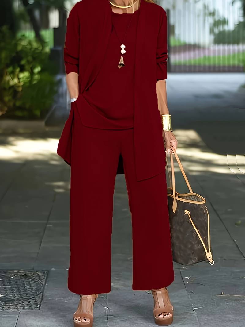 "Driedelige dames outfit grijs: chic vest, bijpassend topje en lange broek voor comfort en stijl."