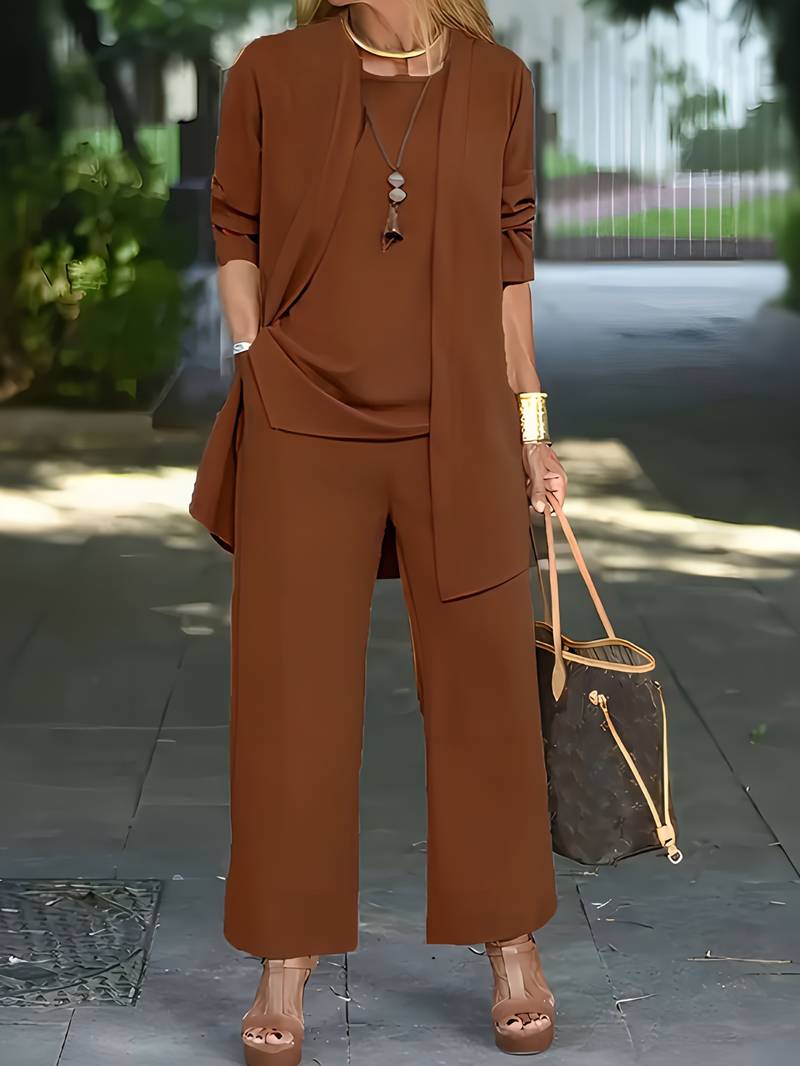 "Driedelige dames outfit grijs: chic vest, bijpassend topje en lange broek voor comfort en stijl."