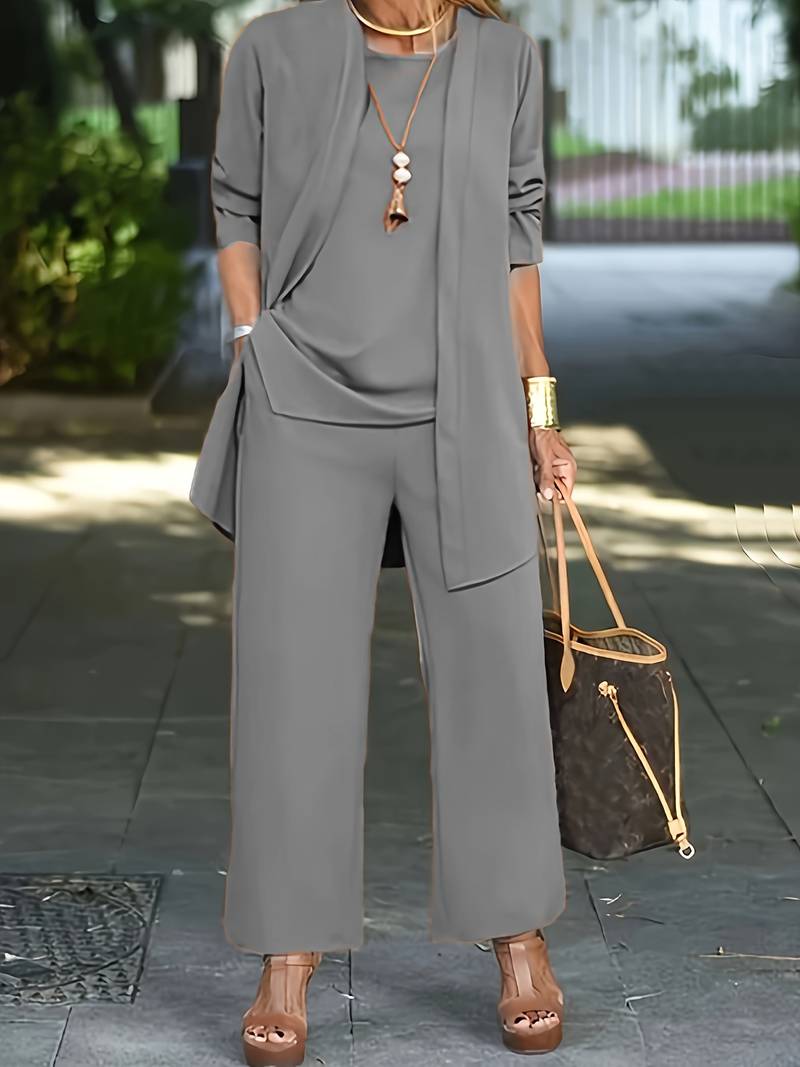 "Driedelige dames outfit grijs: chic vest, bijpassend topje en lange broek voor comfort en stijl."