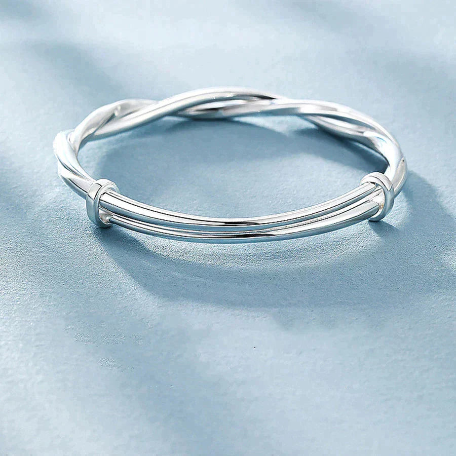 "Elegant gedraaide zilveren armband, verstelbaar, met gedetailleerd ontwerp. Perfect voor elke gelegenheid."