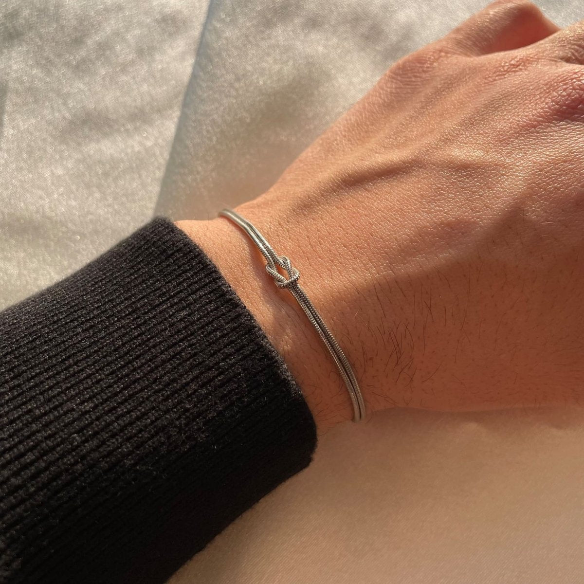"Elegant gouden liefdesknoop armband voor dames, minimalistisch ontwerp, tijdloos en verfijnd accessoire."