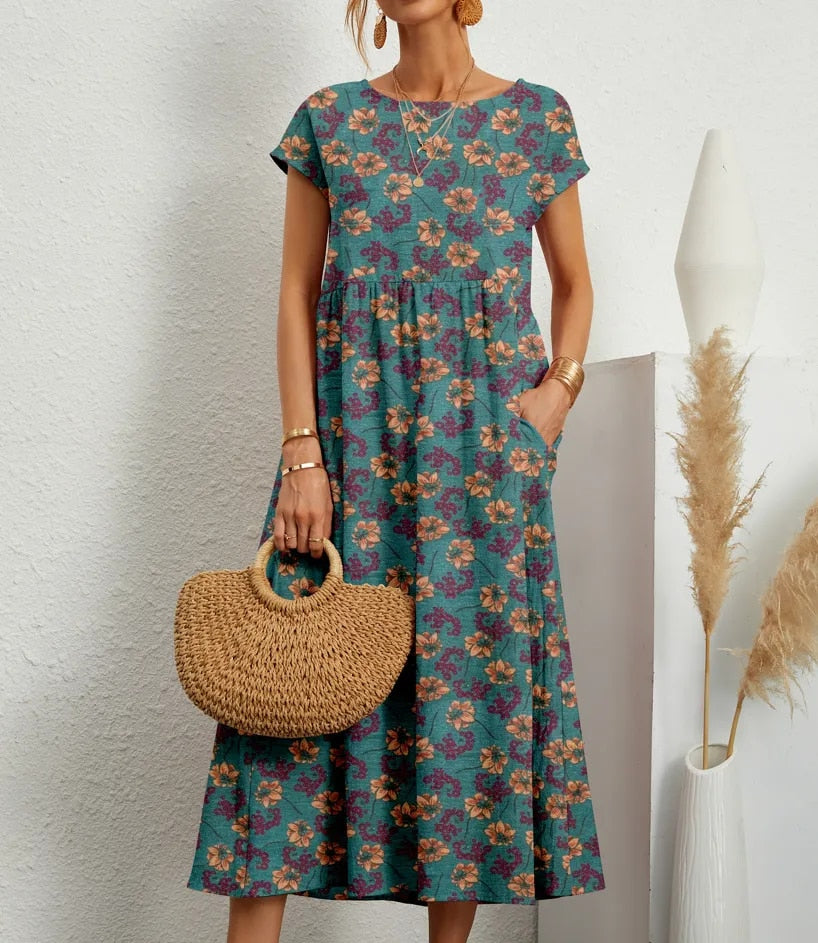 "Elegante A-lijn zomerjurk met kleurrijke bloemenprint, korte mouwen en lange rok, gemaakt van licht katoenen stof."