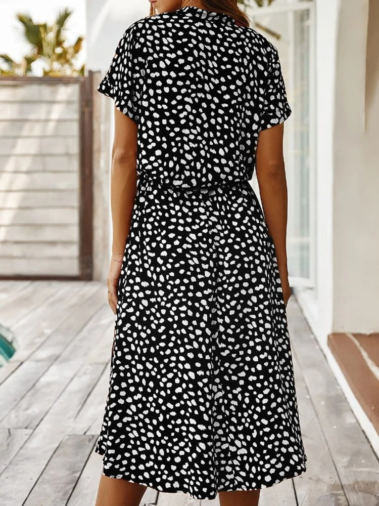 "Elegante midi zomerjurk met kleurrijke bloemenprint, korte mouwen, marineblauw en rood, luchtig en comfortabel."