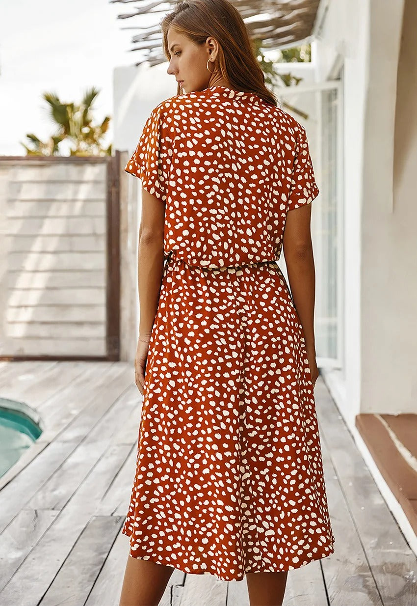 "Elegante midi zomerjurk met kleurrijke bloemenprint, korte mouwen, marineblauw en rood, luchtig en comfortabel."