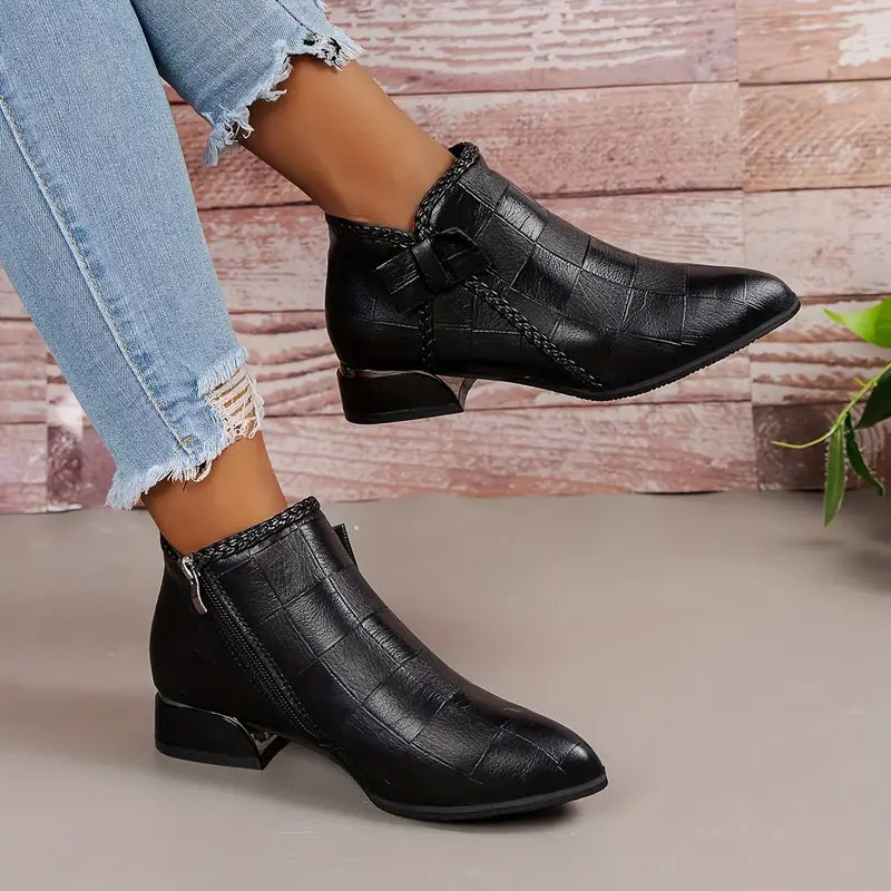 "Elegante zwarte enkellaarzen voor dames met lage hak, verfijnd klassiek design, ideaal voor formele gelegenheden."