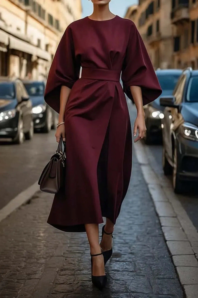 "Elegante zwarte midi-jurk met wijde mouwen, verfijnde tailleband en luxe stof, ideaal voor elke gelegenheid."