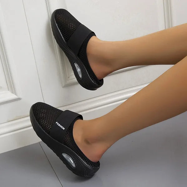 Elegante zwarte orthopedische damesslippers met ademend ontwerp en comfortabel voetbed voor langdurig draagcomfort.