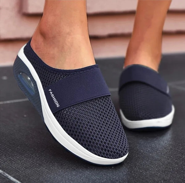 Elegante zwarte orthopedische damesslippers met ademend ontwerp en comfortabel voetbed voor langdurig draagcomfort.