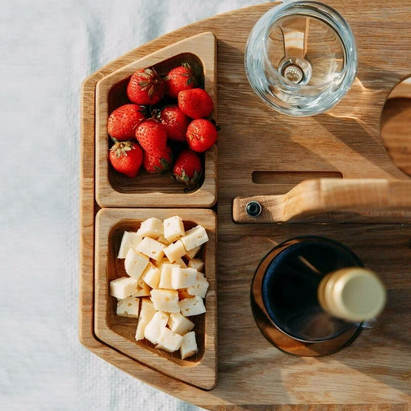 Houten draagbare picknickwijntafel met wijngleuven en ruime serveervakken voor snacks en wijn, ideaal voor buitengebruik.