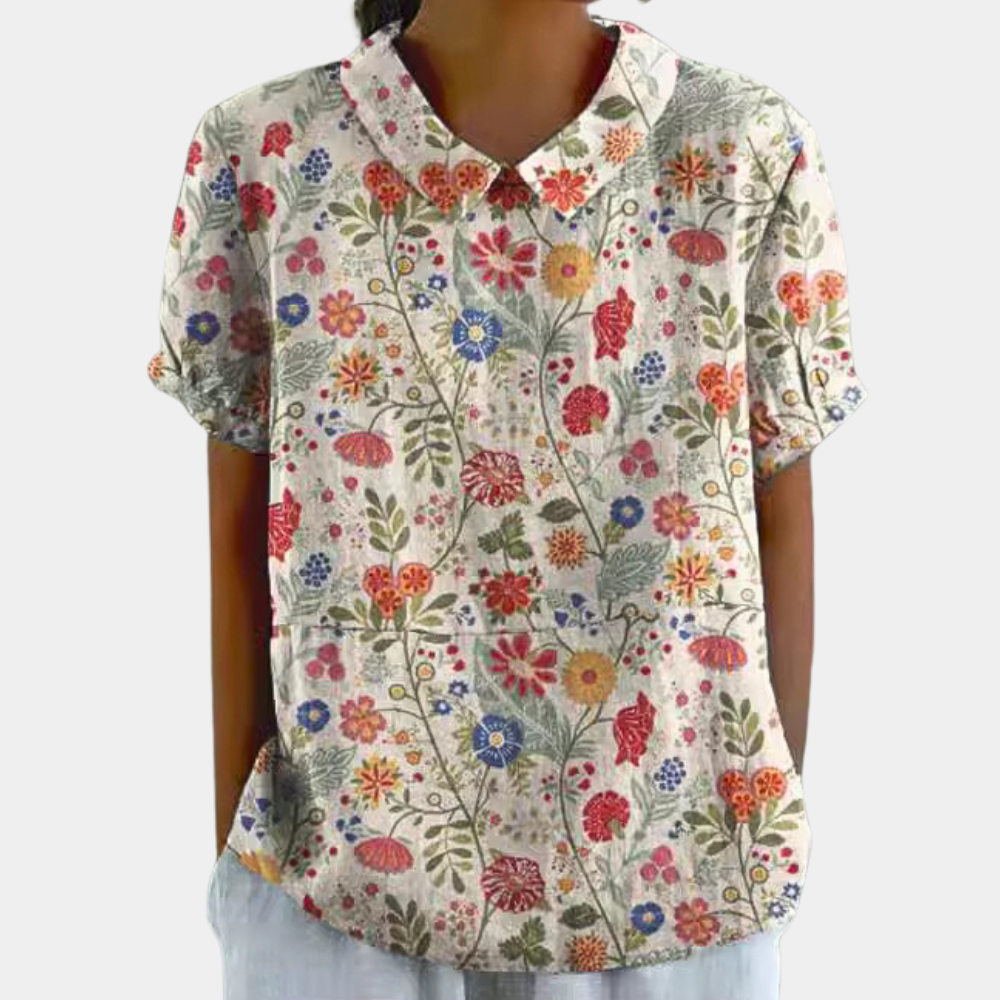 Kleurrijke damesblouse met bloemenpatroon, korte mouwen en ronde kraag, ideaal voor casual zomeroutfits.