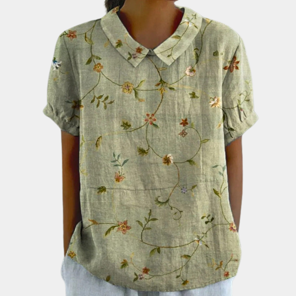 Kleurrijke damesblouse met bloemenpatroon, korte mouwen en ronde kraag, ideaal voor casual zomeroutfits.