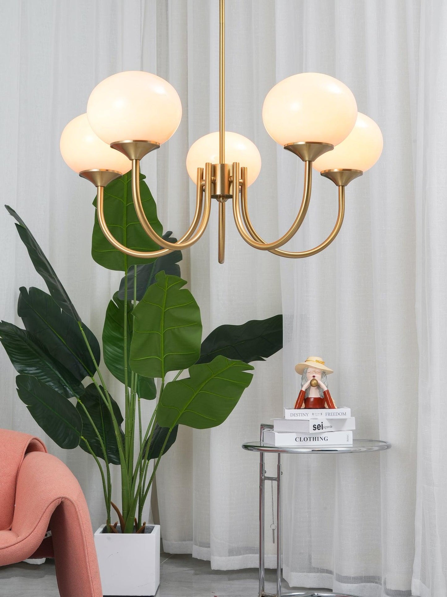 "Moderne kroonluchter met gouden afwerking en roze glazen kappen, geschikt voor LED verlichting in eigentijds interieur."