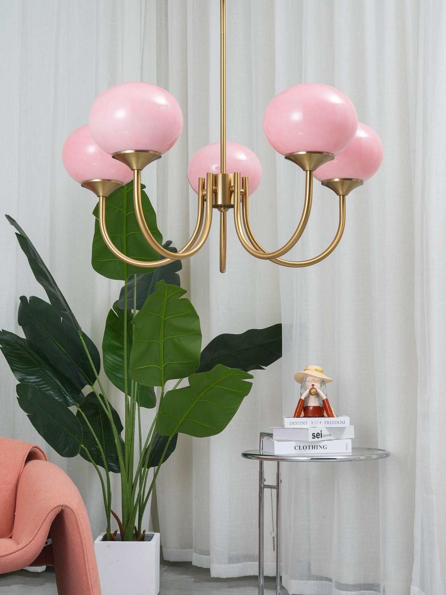 "Moderne kroonluchter met gouden afwerking en roze glazen kappen, geschikt voor LED verlichting in eigentijds interieur."