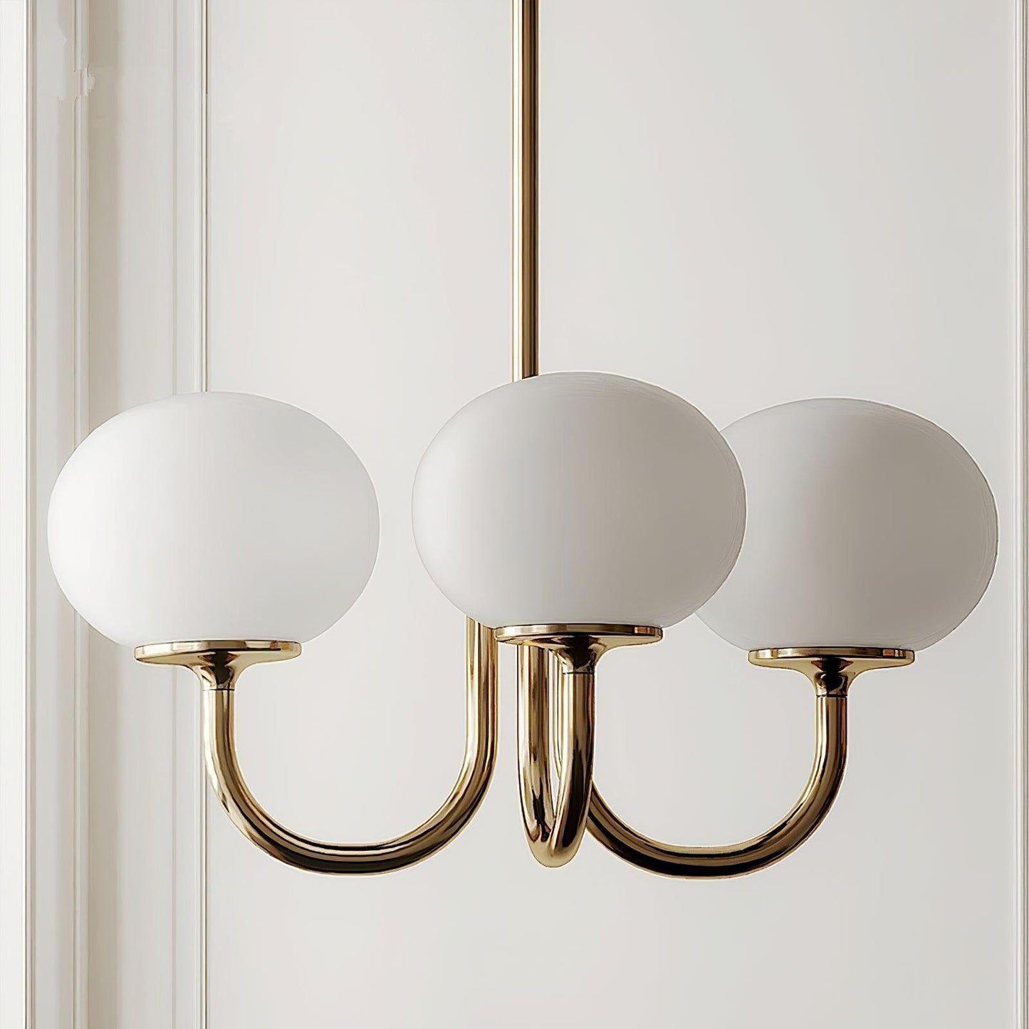 "Moderne kroonluchter met gouden afwerking en roze glazen kappen, geschikt voor LED verlichting in eigentijds interieur."