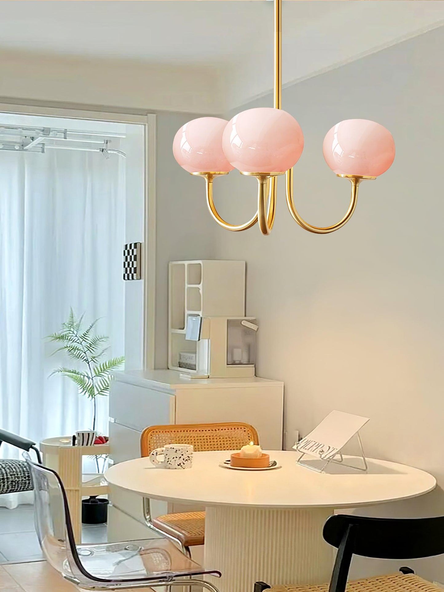 "Moderne kroonluchter met gouden afwerking en roze glazen kappen, geschikt voor LED verlichting in eigentijds interieur."