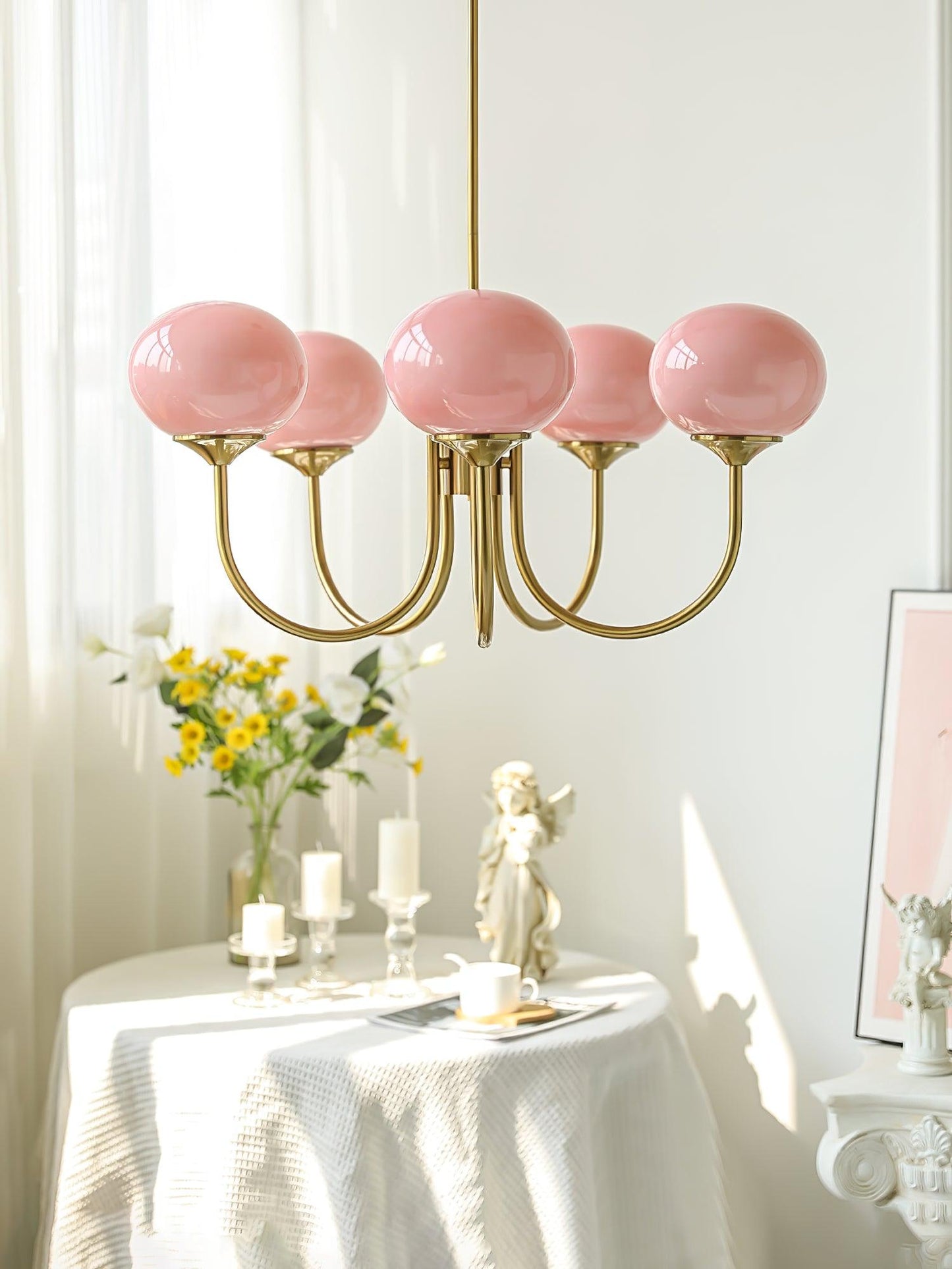 "Moderne kroonluchter met gouden afwerking en roze glazen kappen, geschikt voor LED verlichting in eigentijds interieur."