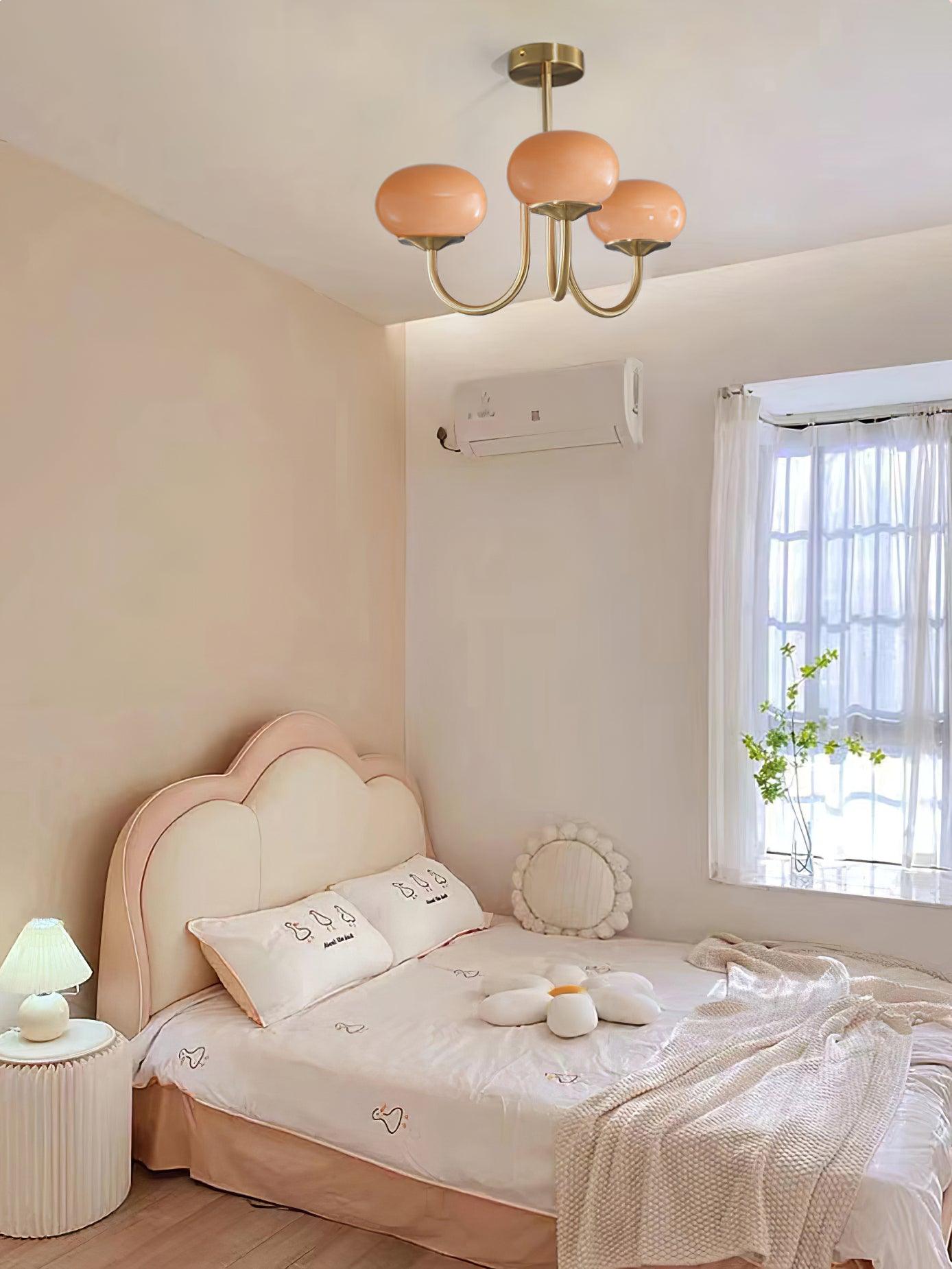 "Moderne kroonluchter met gouden afwerking en roze glazen kappen, geschikt voor LED verlichting in eigentijds interieur."