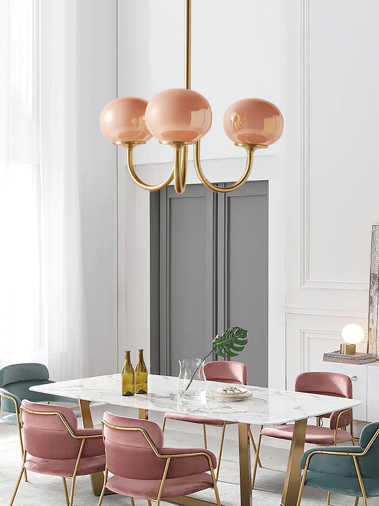 "Moderne kroonluchter met gouden afwerking en roze glazen kappen, geschikt voor LED verlichting in eigentijds interieur."