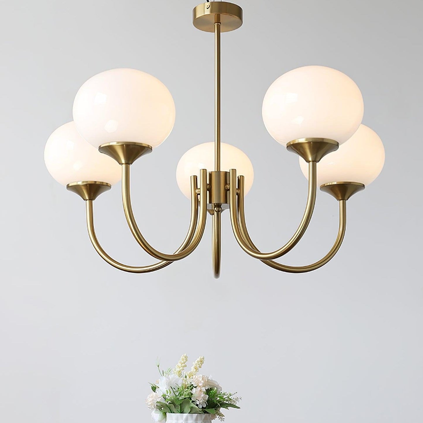 "Moderne kroonluchter met gouden afwerking en roze glazen kappen, geschikt voor LED verlichting in eigentijds interieur."