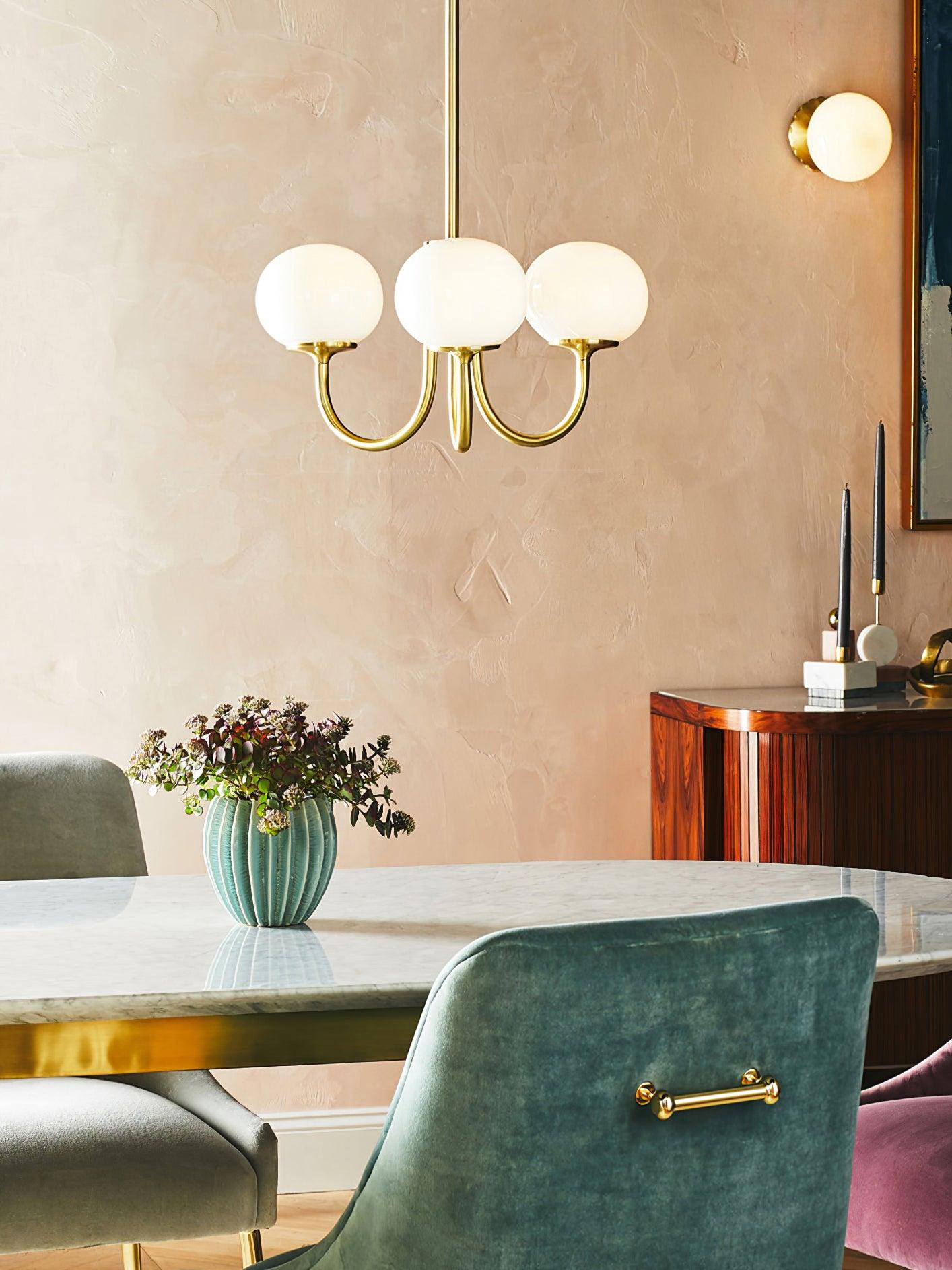 "Moderne kroonluchter met gouden afwerking en roze glazen kappen, geschikt voor LED verlichting in eigentijds interieur."
