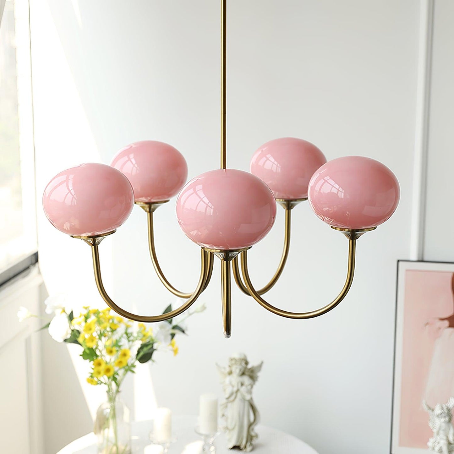 "Moderne kroonluchter met gouden afwerking en roze glazen kappen, geschikt voor LED verlichting in eigentijds interieur."