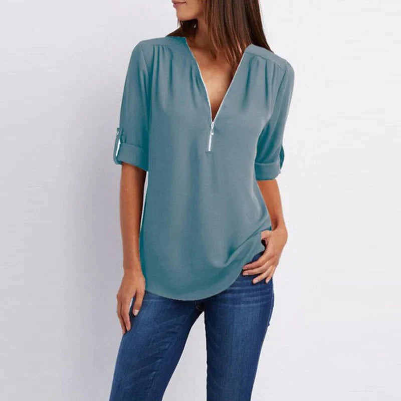 Stijlvolle Vera damesblouse met V-hals en rits in blauw, perfect voor diverse outfits en gelegenheden.