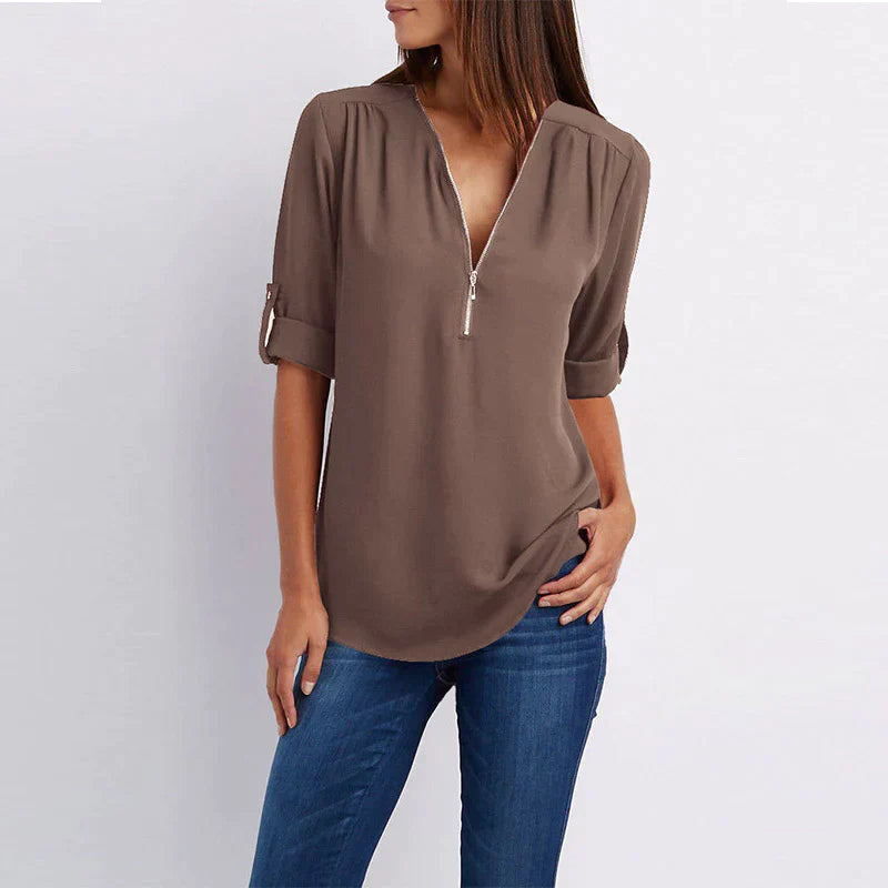 Stijlvolle Vera damesblouse met V-hals en rits in blauw, perfect voor diverse outfits en gelegenheden.