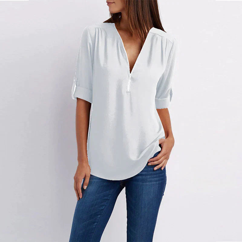 Stijlvolle Vera damesblouse met V-hals en rits in blauw, perfect voor diverse outfits en gelegenheden.