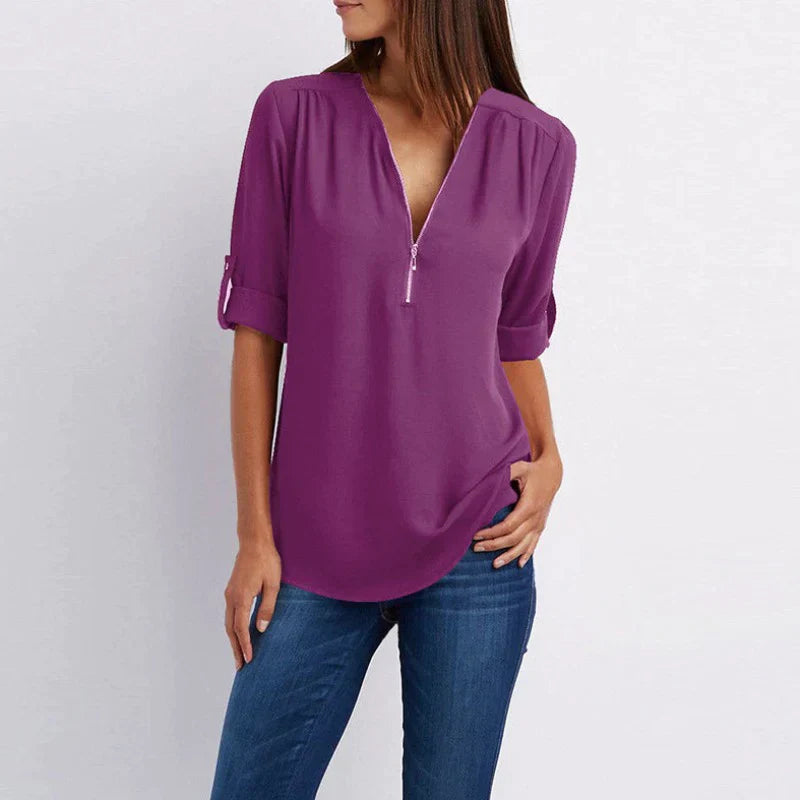 Stijlvolle Vera damesblouse met V-hals en rits in blauw, perfect voor diverse outfits en gelegenheden.