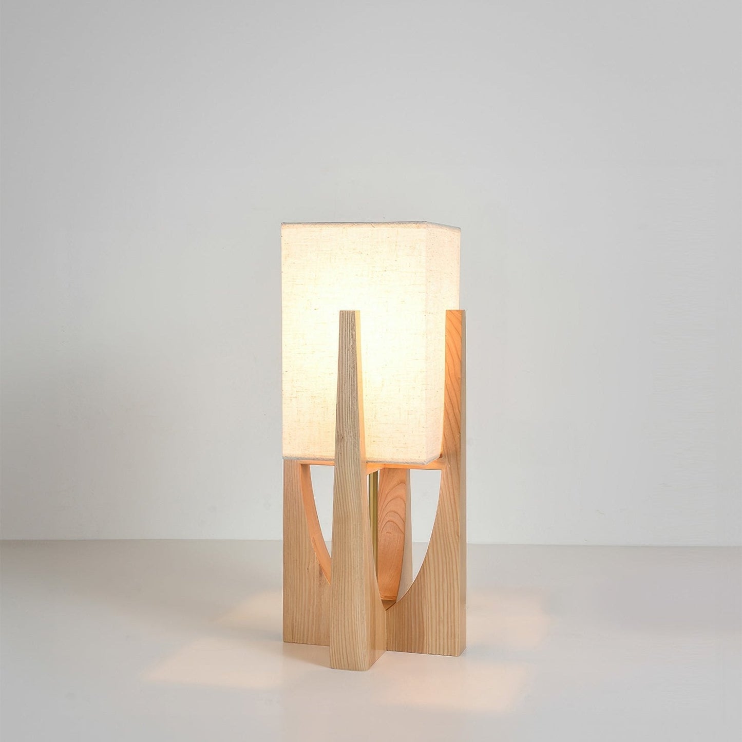 Vloerlamp met walnotenhouten basis, messing accenten en katoenen kap; minimalistisch en elegant voor sfeervol interieur.