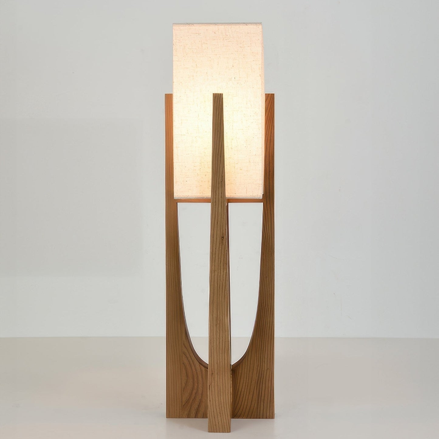 Vloerlamp met walnotenhouten basis, messing accenten en katoenen kap; minimalistisch en elegant voor sfeervol interieur.
