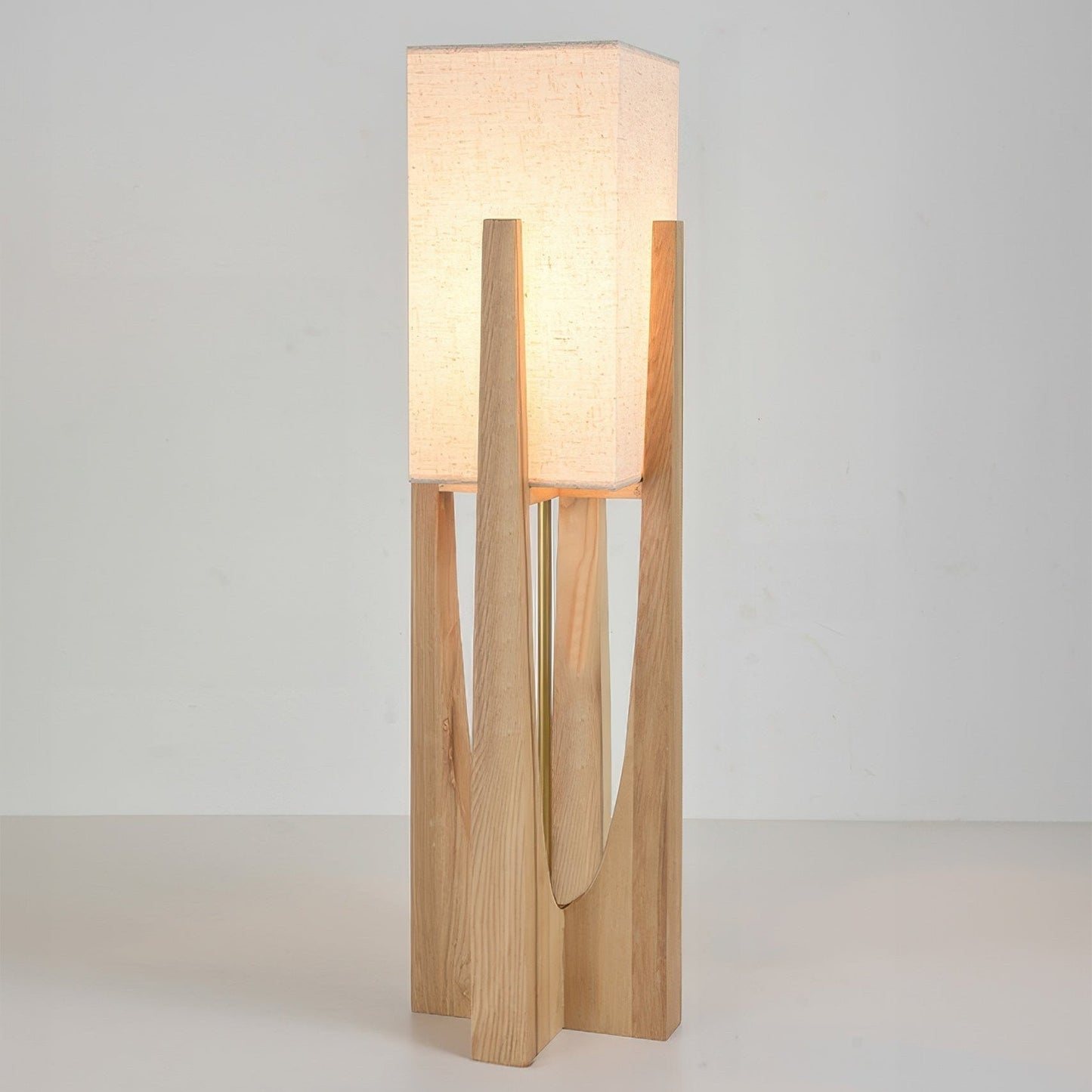 Vloerlamp met walnotenhouten basis, messing accenten en katoenen kap; minimalistisch en elegant voor sfeervol interieur.