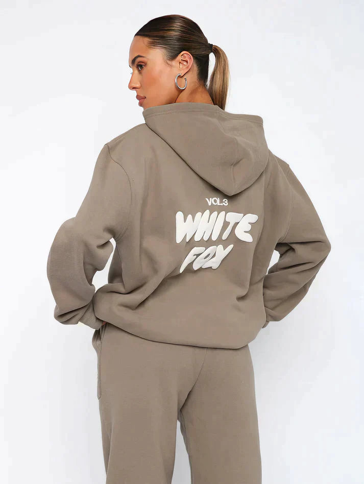 "Witte Vos trainingspak heren, loose fit, vooraanzicht met oversized silhouet en opvallend pofdruklogo."