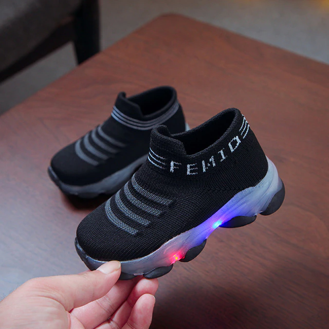 Blauwe lichtgevende kinder sportschoenen voor jongens en meisjes die buiten spelen in de lente/zomer.