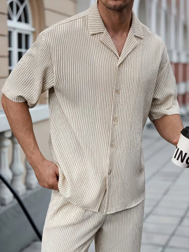 Comfortabele beige heren zomer kledingset, tweedelig met V-hals shirt & broek, perfect voor warme dagen en vakantie.