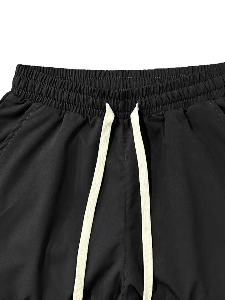 Stijlvolle heren streetwear cargo broek, taps model, met meerdere zakken en elastische boorden voor de modebewuste man.