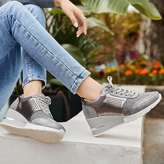 Modieuze damesschoenen: zwarte sleehak sneakers met verhoogde zool, ideaal voor comfort.