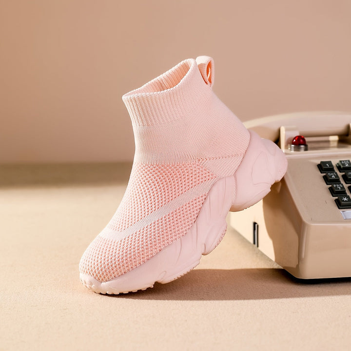 Kind springt in comfortabele lichtgewicht sokschoenen, perfect voor actieve jongens en meisjes.