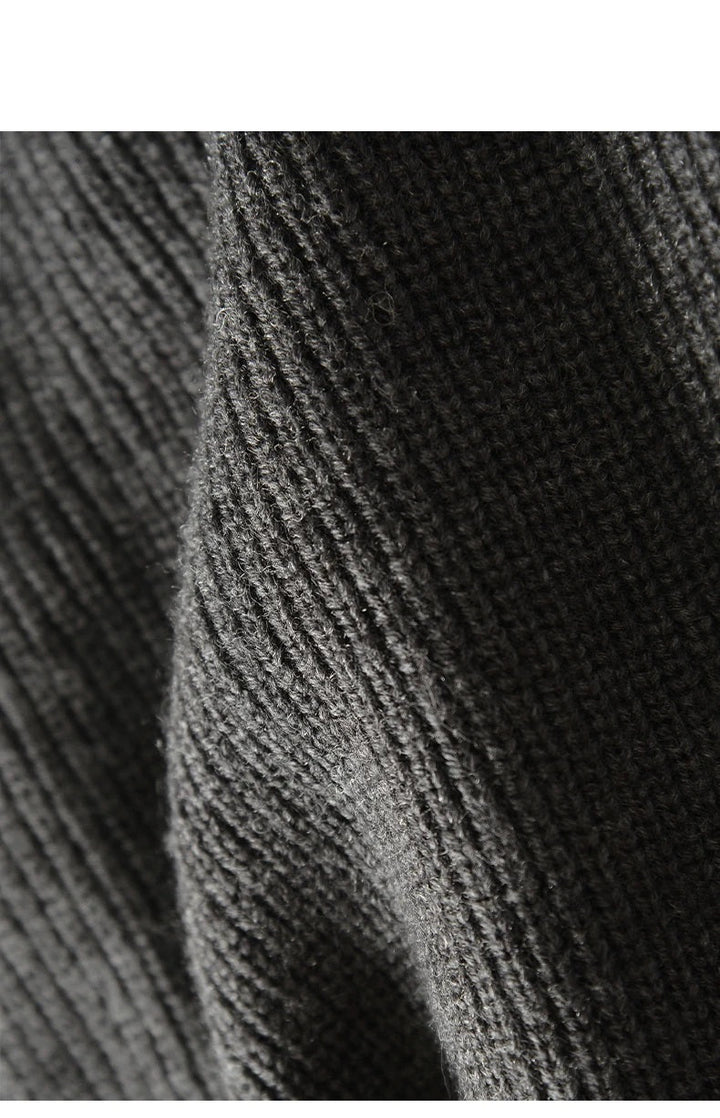 Detail van de textuur en de knopen op een gebreid heren merinowol vest.