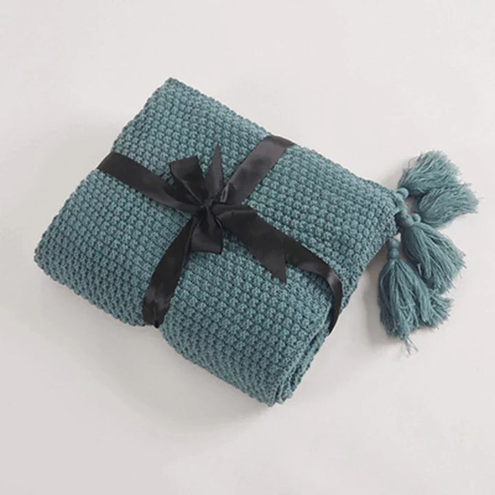 Zachte en warme gebreide wollen plaid met kwastjes, een comfortabel woonaccessoire van NordicCozy.
