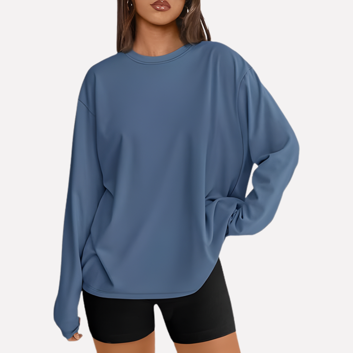 Vrouw poseert in comfortabel oversized lang mouw shirt, toont veelzijdigheid en stijl.